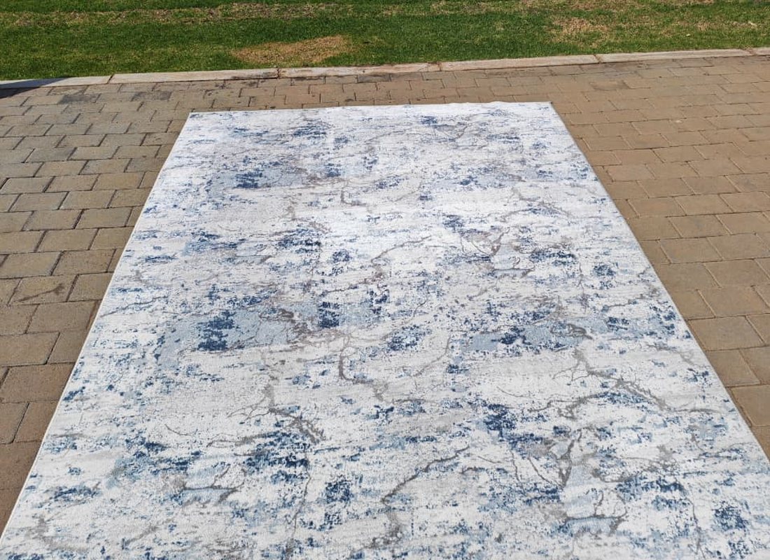 The finished rug laid out clean in the sun before being returned to the client